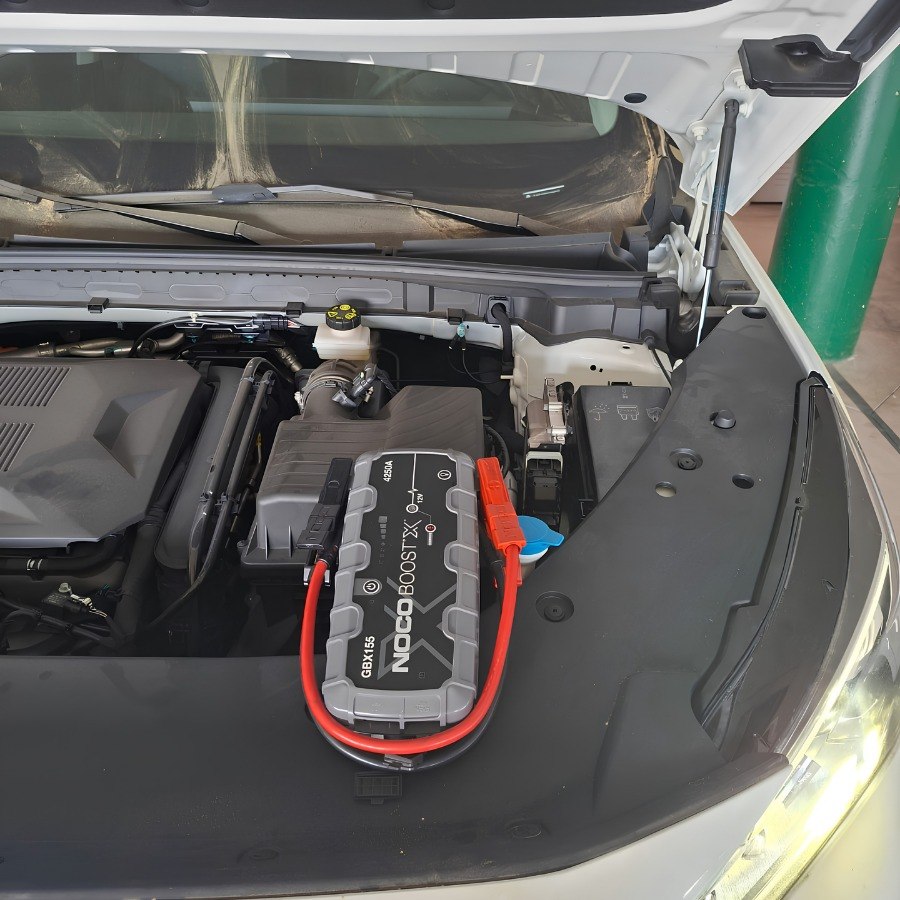 Asistencia con arrancador portátil sobre el vano motor de un coche