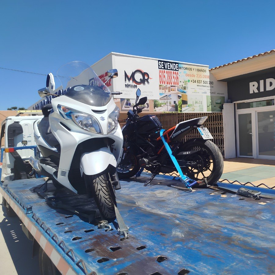 Dos motocicletas aseguradas sobre la plataforma de una grúa